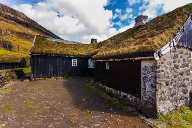 Güzel bir bahar manzarası. Faroe Adaları 'ndaki tipik çim çatılı evleri olan Saksun köyünün güneşli bahar manzarası. Streymoy Adası, Danimarka, Avrupa 'nın muhteşem manzarası.