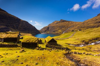 Güzel bir bahar manzarası. Faroe Adaları 'ndaki tipik çim çatılı evleri olan Saksun köyünün güneşli bahar manzarası. Streymoy Adası, Danimarka, Avrupa 'nın muhteşem manzarası.