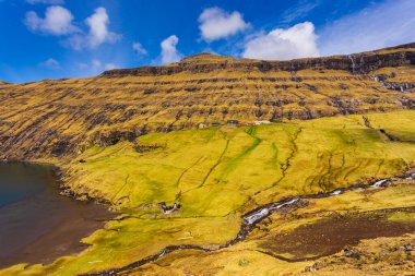 Güzel bir bahar manzarası. Tipik çim-üstü evleri ve Faroe Adaları 'ndaki Pollurin Gölü manzaralı Saksun köyü manzarası. Streymoy Adası, Danimarka, Avrupa 'nın muhteşem manzarası.