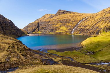 Güzel bir bahar manzarası. Tipik çim-üstü evleri ve Faroe Adaları 'ndaki Pollurin Gölü manzaralı Saksun köyü manzarası. Streymoy Adası, Danimarka, Avrupa 'nın muhteşem manzarası.