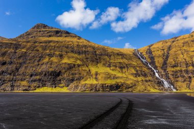 Güzel bir bahar manzarası. Osin Körfezi 'ndeki Pollurin Gölü manzarası ve Faroe Adaları' ndaki dik bir dağ yamacından aşağı akan şelale manzarası. Streymoy Adası, Danimarka, Avrupa 'nın muhteşem manzarası.