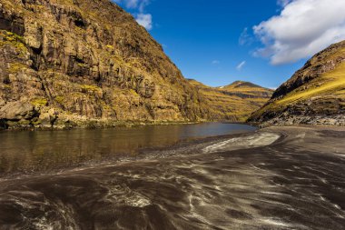 Osin Körfezi, Saksun köyünü Atlantik Okyanusu 'na bağlıyor. Siyah kum ve dik dağ yamaçları. Saksun, Faroe Adaları, Danimarka.