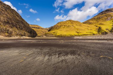 Osin Körfezi 'ndeki karanlık sahil ve dik dağ yamaçları. Saksun köyünü Atlantik Okyanusu 'na bağlayan bir körfez. Saksun, Faroe Adaları, Danimarka.