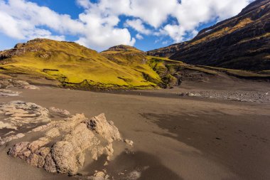 Osin Körfezi 'ndeki karanlık sahil ve dik dağ yamaçları. Saksun köyünü Atlantik Okyanusu 'na bağlayan bir körfez. Saksun, Faroe Adaları, Danimarka.