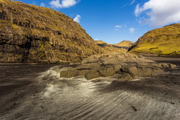 Osin Körfezi 'ndeki karanlık sahil ve dik dağ yamaçları. Saksun köyünü Atlantik Okyanusu 'na bağlayan bir körfez. Saksun, Faroe Adaları, Danimarka.