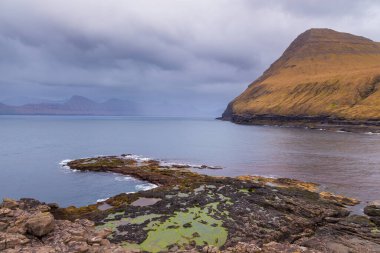 Streymoy Adası 'ndaki Gjogv adalarının dik kıyıları. Güzel gün batımı. Atlas Okyanusu, Faroe Adaları 'ndaki volkanik takımadalar.