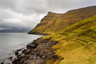 Dik kıyı, Eysturoy adasındaki dağ manzarası. Bulutlu bahar günü. Elduvik, Faroe Adaları, Danimarka.