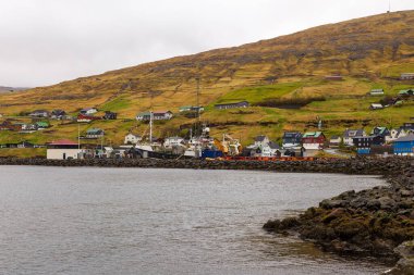 Streymoy adasındaki tepenin yamacında küçük bir liman kasabası. Vestmanna, Faroe Adaları..