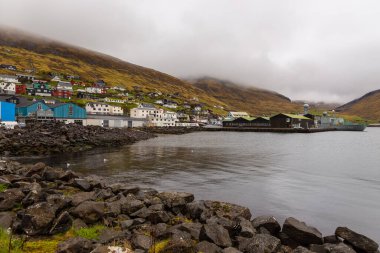 Streymoy adasındaki tepenin yamacında küçük bir liman kasabası. Vestmanna, Faroe Adaları..