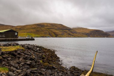 Vestmanna, Faroe Adaları - 05 Mayıs 2018: Streymoy adasındaki tepenin yamacında yer alan küçük liman kasabası.