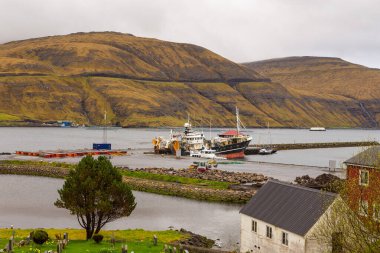 Vestmanna, Faroe Adaları - 05 Mayıs 2018: Streymoy adasındaki tepenin yamacında yer alan küçük liman kasabası.