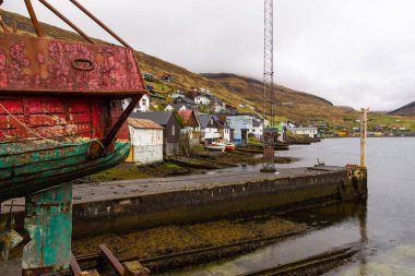 Vestmanna, Faroe Adaları - 05 Mayıs 2018: Kuru bir rıhtıma demirlenmiş eski bir ahşap kesici. Streymoy adasındaki tepenin yamacında küçük bir liman kasabası..