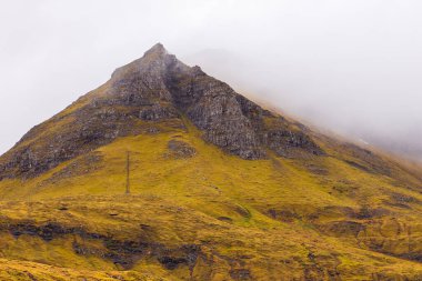 Streymoy adasındaki dağ manzarası. Bulutlu bahar günü. Dağlardan akan şelaleler. Leynar, Faroe Adaları.