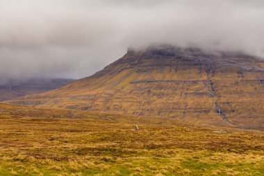 Streymoy adasındaki dağ manzarası. Bulutlu bahar günü. Dağlardan akan şelaleler. Leynar, Faroe Adaları.
