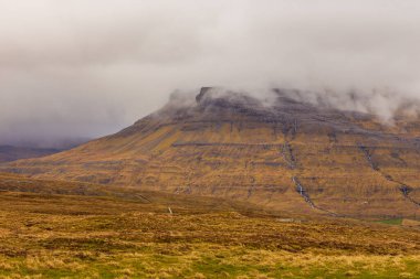 Streymoy adasındaki dağ manzarası. Bulutlu bahar günü. Dağlardan akan şelaleler. Leynar, Faroe Adaları.