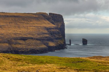 Risin og Kellingin kaya oluşumları Eysturoy Adası kıyılarında. Kıyı şeridi kayalıkları manzarası. Eidi, Faroe Adaları, Danimarka.