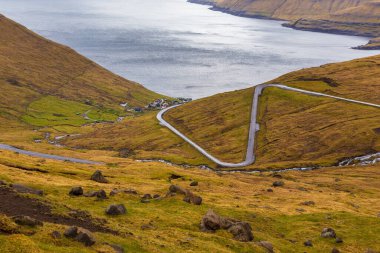 Eysturoy adasındaki dağ manzarası. Bulutlu bahar günü. Dağlardan akan şelaleler. Eğlence Komünü, Faroe Adaları.