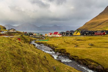Gjogv, Faroe Adaları, Danimarka - 05 Mayıs 2018: Eysturoy adasındaki dağın yamacında yer alan küçük bir köy. Geleneksel ahşap ev.