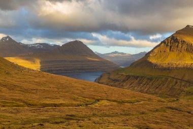 Faroe Adaları üzerinde gün batımı, Atlantik Okyanusu 'nda volkanik bir takımada. Eğlence Komünü, Eysturoy Adası, Faroe Adaları.