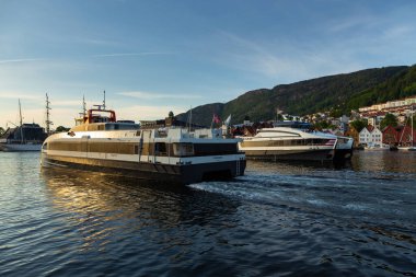 Bergen, Norveç - 27 Mayıs 2018: Bryggen manzarası, Vagen limanının doğu tarafında sıralanan bir dizi Hanseatic mirası ticari binaları. Feribot yolcuları.