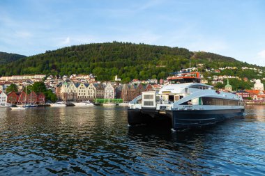 Bergen, Norveç - 27 Mayıs 2018: Bryggen manzarası, Vagen limanının doğu tarafında sıralanan bir dizi Hanseatic mirası ticari binaları. Feribot yolcuları.