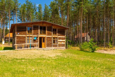 Wdzydze Kiszewskie, Polonya - 31 Mayıs 2018: Kashubian Etnoğrafya Parkı açık hava müzesindeki kır evi. Arka planda Hollanda tipi yel değirmeni.