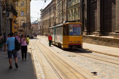 Lviv, Ukrayna - 09 Haziran 2018: Tarihi Lviv kasabasındaki geleneksel binalar. Sarı tramvay durakta..