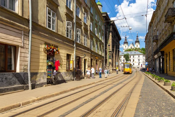 Lviv, Ukrayna - 09 Haziran 2018: Tarihi Lviv kasabasındaki geleneksel binalar. Sarı tramvay durakta..