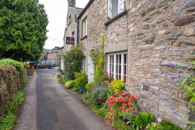 Kirkby Lonsdale, Cumbria, İngiltere - 12 Ağustos 2018: Pazar kasabasında dar sokaklar. Geleneksel taş evler.