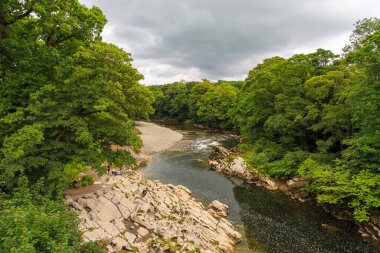 Kirkby Lonsdale, South Lakeland, Cumbria, England, UK - 12 August 2018: People on the River Lune. Devils Bridge area.