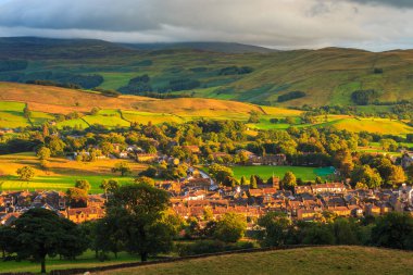 Sedbergh, İngiltere - 13 Ağustos 2018: Sedbergh köyünün manzarası. Yorkshire Dales, Cumbria 'daki yeşil tepelerde gün batımı. Kırsal alan.