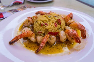 Beyaz tabakta servis edilen acı biberli ve karidesli risotto..