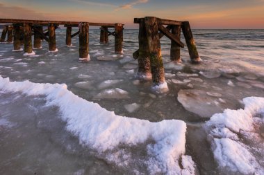 Sabahın erken saatlerinde Sopot sahilindeki küçük iskelenin donmuş elementlerinde. Polonya Sopot 'ta kış manzarası.