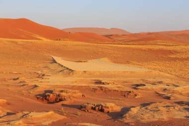 Kum tepesinden Sossusvlei 'nin tuz tepesine inanılmaz bir manzara. Namib Naukluft Ulusal Parkı. Sossusvlei 'deki kum tepeleri. Gün doğumu. Namibya. Afrika.