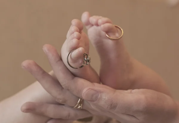 Anéis de casamento em um pequeno bebê pés — Fotografia de Stock