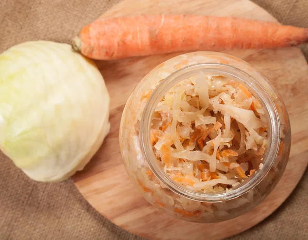 Sauerkraut in a glass jar and carrot and cabbage — Stock Photo, Image