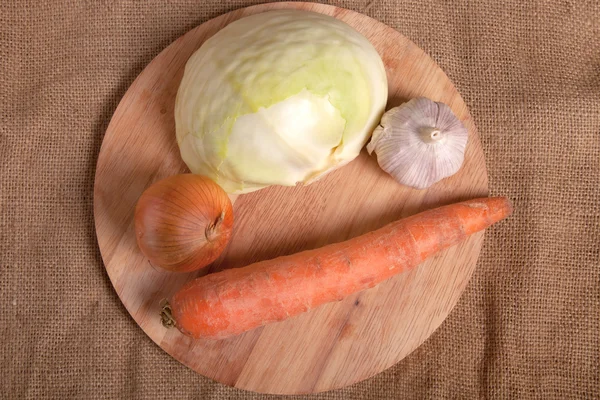 Sauerkraut, bacon, onion and garlic on a sacking — Stock Photo, Image