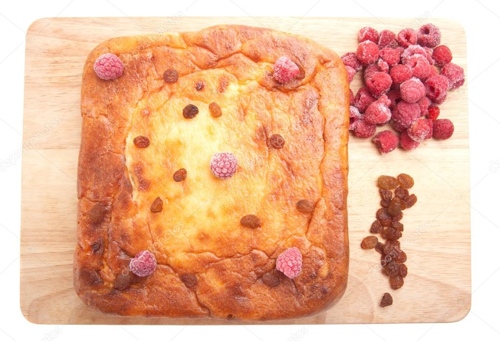 Cottage cheese casserole with raspberries, raisins on a white ba