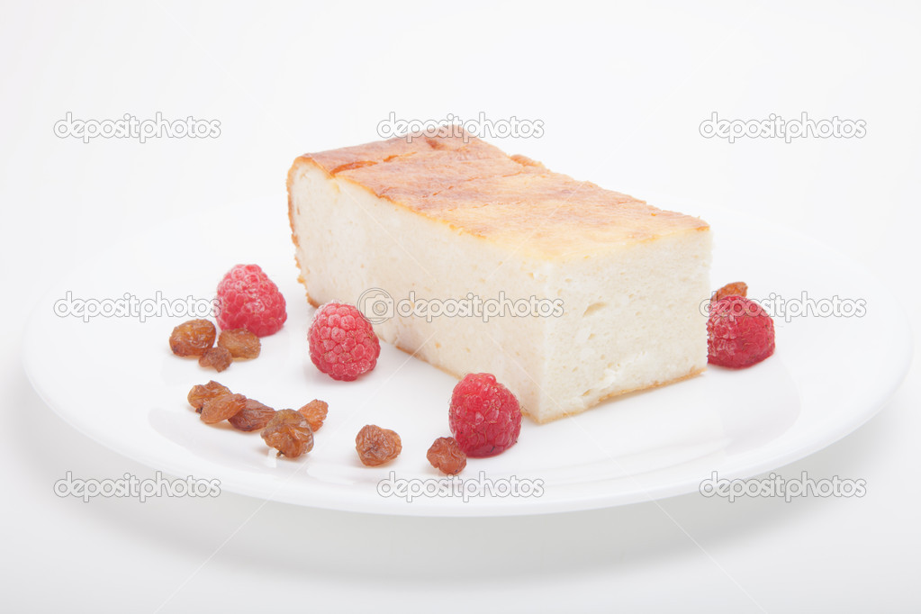 Cottage cheese casserole with raspberries, raisins on a white ba
