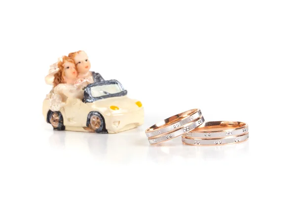 Anillos de boda junto a un juguete chocolate máquina aislamiento en un whi —  Fotos de Stock