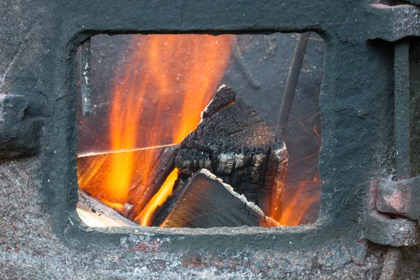 Bois et le feu dans le four avec des étincelles volantes — Photo