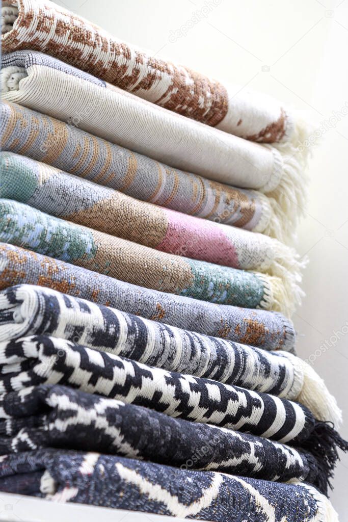 Textile industrial background with fabric texture, variation of multicolored soft cotton rugs and warm blankets stacked.