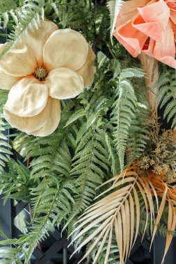 Yapay çiçek ve dekoratif yaprakların dokusuna sahip soyut bir arka plan.