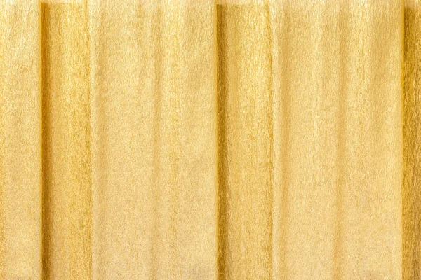 Golden abstract shiny corrugated pleated background with yellow wrapping crumpled paper texture for gift decor — Stockfoto