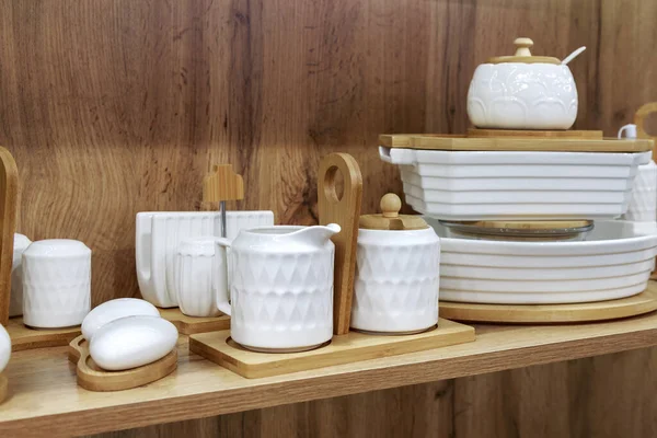 White clean china dishes on a wooden shelf. Department of crockery, household goods. Kitchen interior design — Foto de Stock
