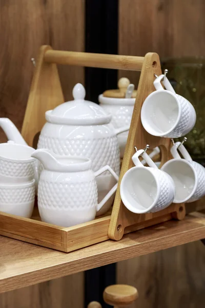 Białe czyste porcelanowe naczynia do herbaty na drewnianej półce. Departament naczyń, artykułów gospodarstwa domowego. Kuchnia wystrój wnętrz — Zdjęcie stockowe