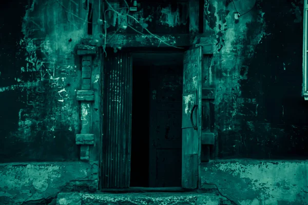 Open door entrance to a dark basement corridor of an abandoned ruined scary strange mystical house with black shadows and blue green moon mysterious light in horror style — Stockfoto