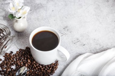 Coffee morning hot black drink in a white cup and roasted beans on the table top view