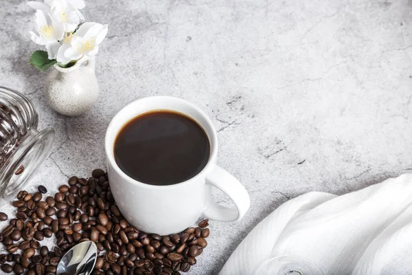 Coffee morning hot black drink in a white cup and roasted beans on the table top view