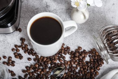 Coffee morning hot black drink in a white cup and roasted beans on the table top view